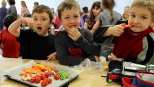 Three elementary students eating a healthy lunch
