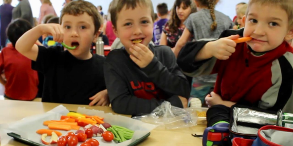 Three elementary students eating a healthy lunch
